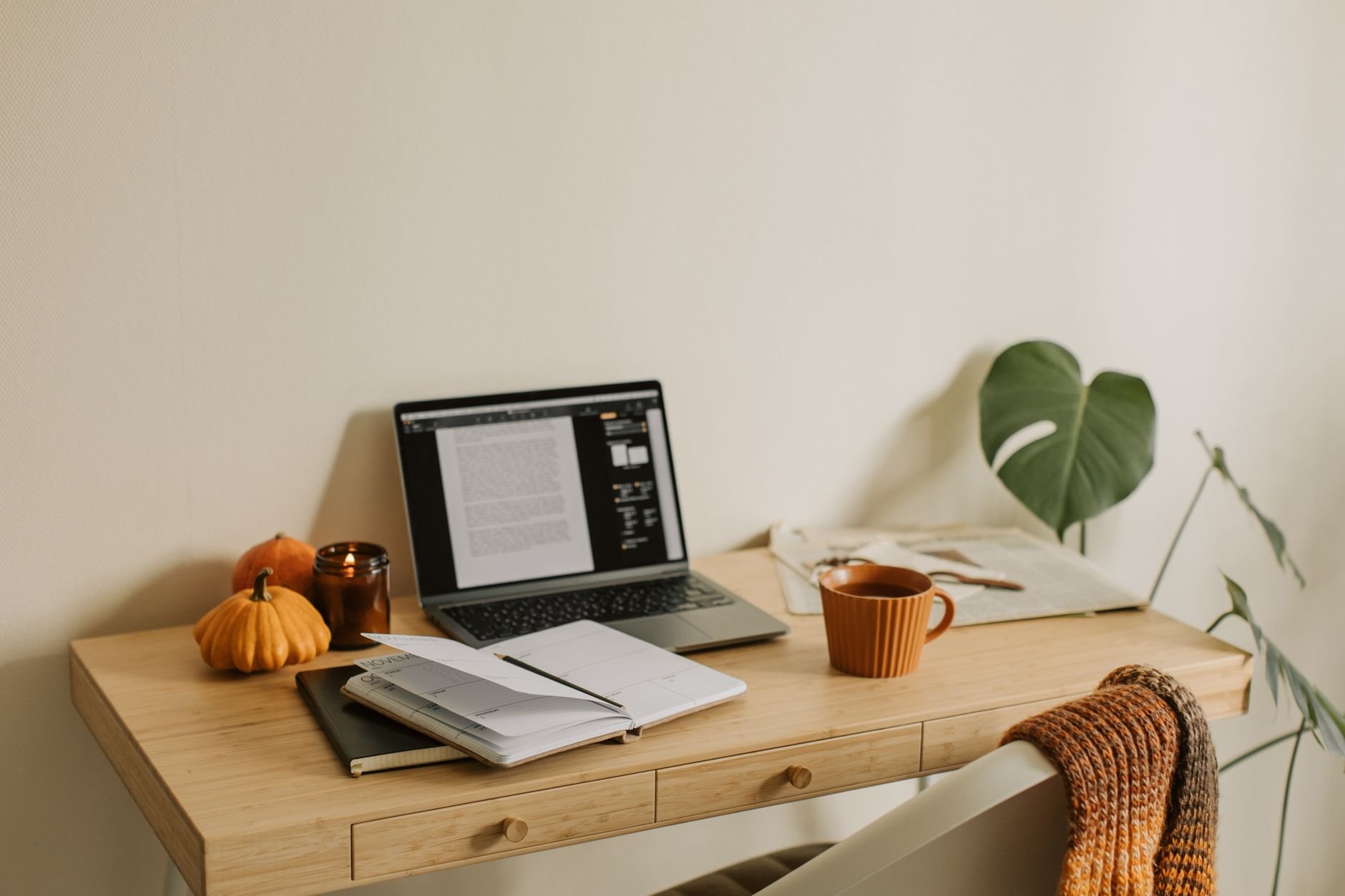 Warm home office workspace with laptop and autumn decor
